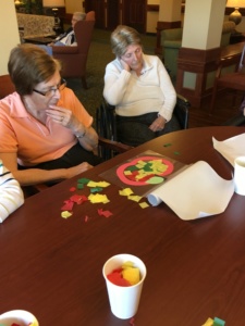 Apple Crafts-Eagan Pointe Senior Living-Harriet puzzling over her apple decorations