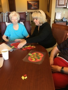 Apple Crafts-Eagan Pointe Senior Living-Linda R. getting assistance with her craft