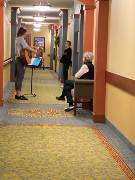 Enjoying a hallway sing-along while practicing social distancing.
